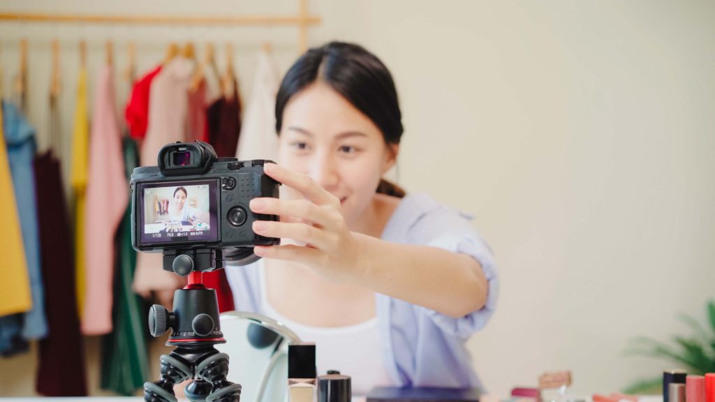 beauty blogger present beauty cosmetics sitting front camera recording video